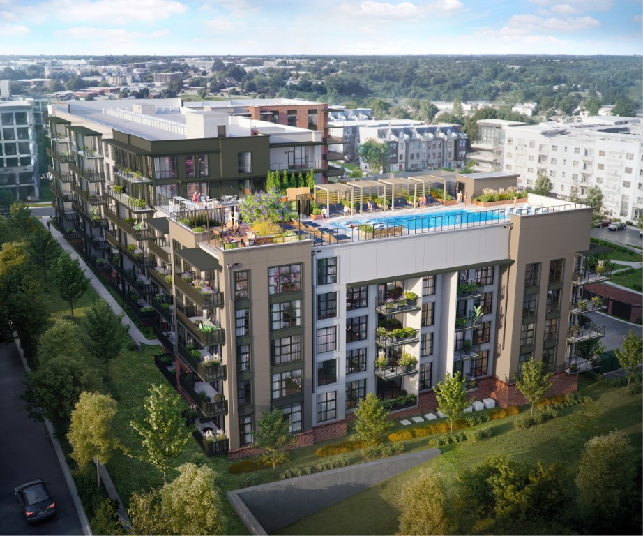 A modern apartment building with balconies, rooftop pool, and lounge area, surrounded by trees and other buildings.