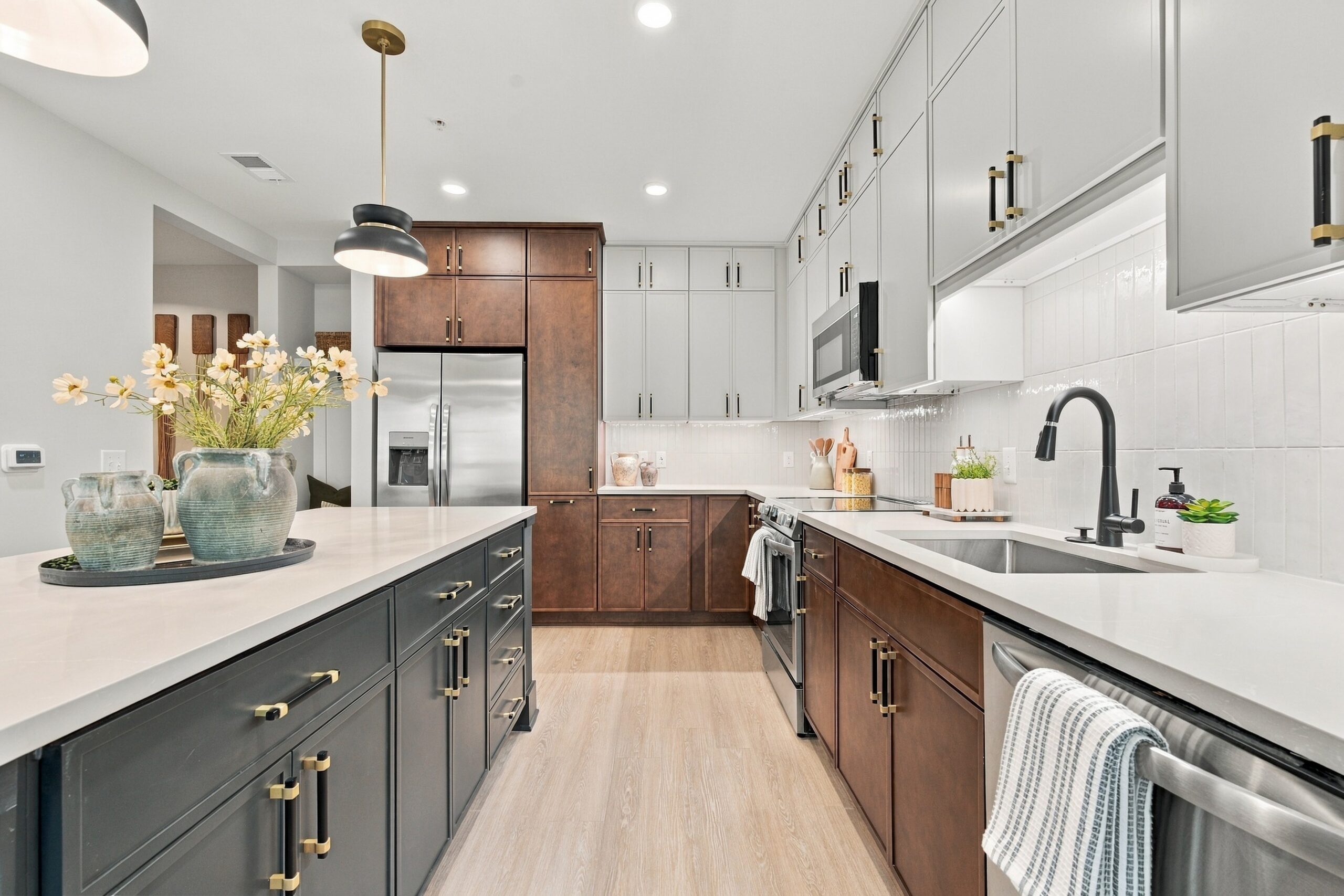 Modern kitchen with dark cabinets, a white island, and gold hardware.